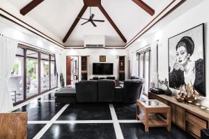 a living room with a couch and a tv at Villa Banyak | Luxury 4Br villa with nice terrace and personal playground in Ban Saiyuan (1)