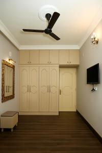a living room with a ceiling fan and a tv at City Haven by JadeCaps2BHKAlipore in Kolkata