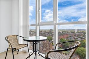 a table and two chairs in front of a window at Sky Scraper London Luxury 1BR Roof Terrace and Gym in London