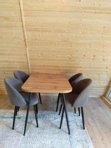 a wooden table and chairs in a room at Aframe AI-ADIL in Saty