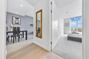 a bedroom with a mirror and a dining room with a table at Sky Scraper London Luxury 1BR Roof Terrace and Gym in London +24 photos