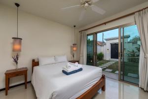 Un dormitorio con una cama y una ventana grande en Villa Kaheru | 3 bedroom priavate pool villa | Kokyang Estate, en Nai Harn Beach 24 fotos más