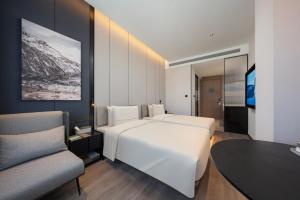 Rúm í herbergi á Atour Hotel Beijing Zhongguancun Software Park West Shangdi Road