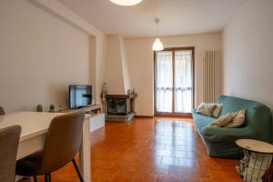 a living room with a table and a green couch at L'Abete - Introbio Apartment in Introbio