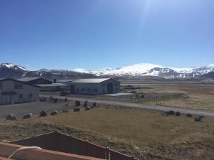 a view of a building with snow covered mountains in the background at North Star Apartments Rif in Snæfellsbær