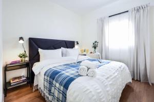 una camera da letto con un letto con due asciugamani sopra di Charming 1BR Apt w Balcony In the Heart of TLV with Mamad by Sea N' Rent a Tel Aviv Altre 9 foto