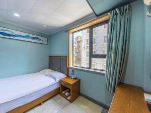 a small bedroom with a bed and a window at FERONIA Hotel Gansu Lanzhou Chengguan District Gannan Road in Lanzhou