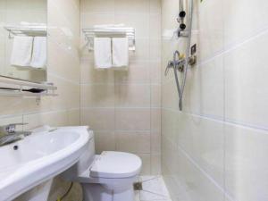 a bathroom with a toilet and a sink and a shower at FERONIA Hotel Gansu Lanzhou Chengguan District Gannan Road in Lanzhou