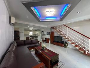sala de estar con sofá y TV en el techo en Grosvenor Square Kandi Realty, en Ángeles
