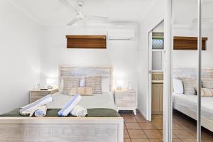 een slaapkamer met twee bedden en een spiegel bij Sunset Oasis in Airlie Beach +12 foto's