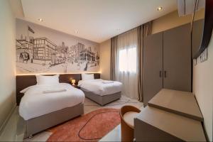 a hotel room with two beds and a desk at Saden Albwadi in Jeddah