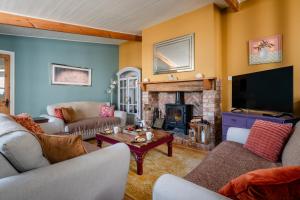 a living room with a fireplace and a tv at Clementine Cottage, Hot Tub, Pool Table, Holcombe Beach 600m in Dawlish