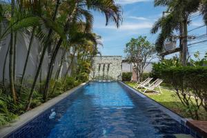 a swimming pool in a backyard with palm trees at VILLA ATA | Private Pool | Saiyuan Estate by Tropiclook | Nai harn beach in Nai Harn Beach