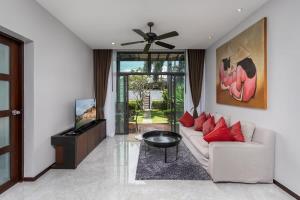 a living room with a white couch and a tv at VILLA ATA | Private Pool | Saiyuan Estate by Tropiclook | Nai harn beach in Nai Harn Beach