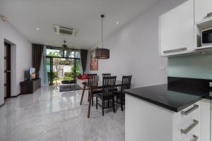 a kitchen and dining room with a table and chairs at VILLA ATA | Private Pool | Saiyuan Estate by Tropiclook | Nai harn beach in Nai Harn Beach