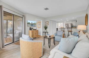 a living room with a white couch and a table at 202 D Port O Call by AvantStay Beach Condo in Isle of Palms