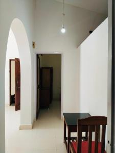 a dining room with a table and a hallway at Candolim Beach Apartments Goa in Candolim