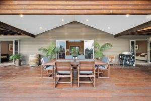 a patio with a wooden table and chairs at Lilies Lakeside Spa Villa - 2 Bedroom in Lovedale