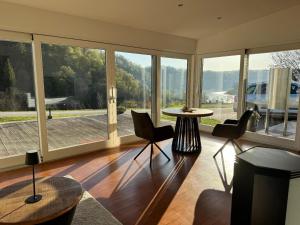 a living room with a table and chairs and large windows at Ferienwohnung Donaublick in Passau