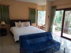 a bedroom with a large bed and a blue couch at Raisubsomboon Resort in Ban Don Wan