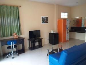 a living room with a blue couch and a tv at Raisubsomboon Resort in Ban Don Wan