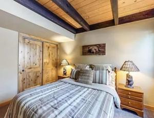 a bedroom with a bed and a wooden ceiling at Streamside Townhome in Kings Beach +21 photos