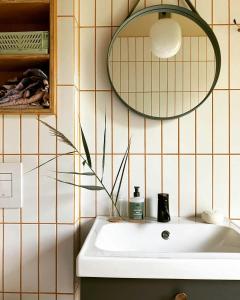 un baño con lavabo y espejo en House In The Woods Near Beach With Peaceful Vibes, en Saeby