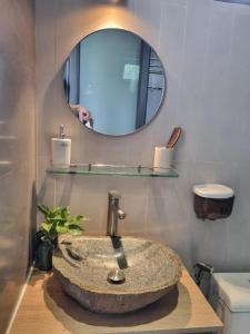 un bagno con un lavandino in pietra e uno specchio di Nha Trong Pho - The Chilling House a Buôn Ma Thuột