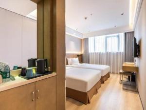 a hotel room with two beds and a television at Xiang Mei Hotel - Jingtianbei Branch in Shenzhen