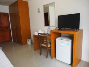a room with a tv and a table with a chair at Phetsuwan Hotel in Phetchabun
