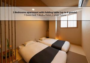 two beds in a small room with avertisementvertisement at 白樺の宿 恵美須, Shirakabanoyado EBISU, SELF CHECK-IN ONLY in Osaka +55 photos