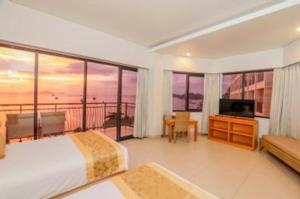 a bedroom with a bed and a view of the ocean at Laprima Hotel in Labuan Bajo