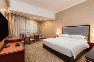 um quarto de hotel com uma cama grande e uma escrivaninha em Century Plaza Hotel em Shenzhen