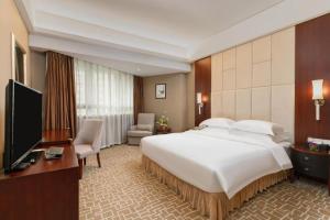 a hotel room with a large bed and a television at Century Plaza Hotel in Shenzhen