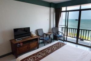 une chambre avec un lit et une télévision et un balcon dans l'établissement Sea Memories White Sand Beach Hotel, à Hua Hin
