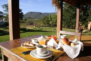 a table with a breakfast of coffee and food on it at Pousada Vale das Araras in Cavalcante