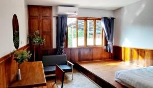 a bedroom with a bed and a desk and a chair at Mon Chang Home in Mae Rim