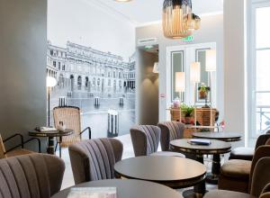 a restaurant with tables and chairs and a mural of a building at 1er Etage Opéra in Paris