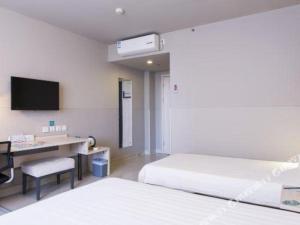 a hotel room with two beds and a desk and a television at Jinjiang Inn Dalian Jinzhou Hengda Garden in Jinzhou +77 photos