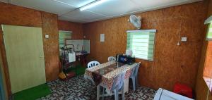 瓜拉江沙Chalet Kampong Guar, Manong的一间有桌子、椅子和窗户的餐厅