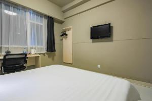 ein Schlafzimmer mit einem Bett, einem Schreibtisch und einem Fernseher in der Unterkunft Jinjiang Inn Xi'an Huimin Street Zhonglou Metro Station in Xi'an