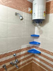 eine Dusche mit blauen Fliesen und einem Wassertank in der Unterkunft Om Home Stay 3Bhk Near Ram Mandir in Ayodhya