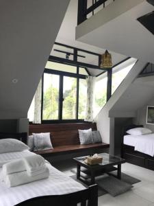 una camera con due letti e una panca di fronte a una finestra di Varn Boutique Resort a Mu Si