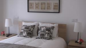 a bed with two black and white pillows on it at Casa De Soudos in Soudos