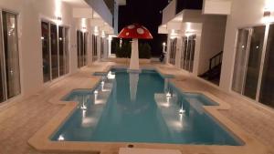 a swimming pool with a red umbrella in the middle of a building at Mestyle Resort in Chumphon