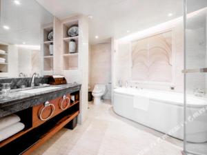a bathroom with a tub and a sink and a toilet at Horizon Hotel in Kunming +230 photos