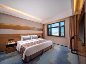 a hotel room with a bed and a large window at Horizon Hotel in Kunming