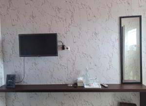 a television sitting on a shelf next to a mirror at Hotel Sudut Tidur in Stasiun Tawang +6 photos