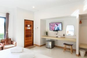 a white room with a desk and a mirror at Baan Klang Suan Resort in Sathani Lang Suan
