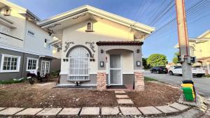 a small white house with a gate in a yard at Casa Esperanza 1376 in Dauis